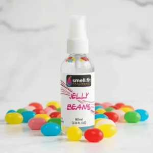 Product image of Smell.fit Fragrance 'Jelly Beans' 80ml (2.8 FL OZ) mist spray bottle. The bottle is surrounded by a colorful pile of bright, assorted jelly beans, set on a white marble surface.